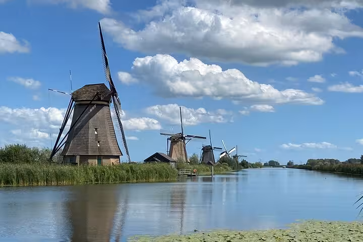 Kinderdijk windmills reflected on canal, iconic UNESCO stop on Famous Holland day tour from Amsterdam