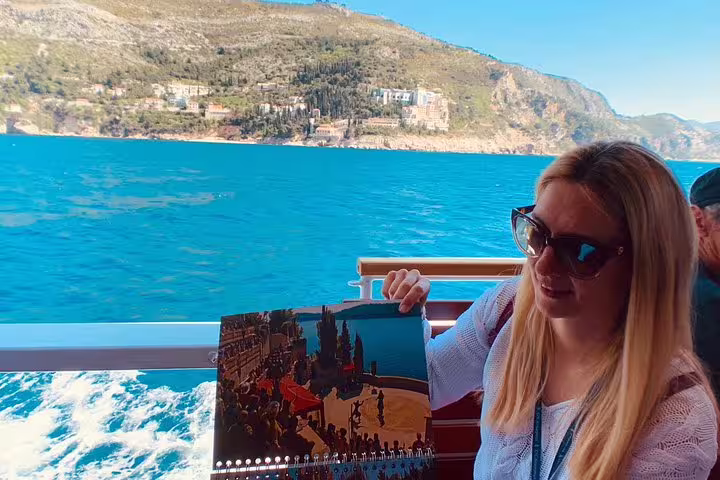 Boat ride to Lokrum, guest holding Iron Throne scene book on King’s Landing Game of Thrones group tour