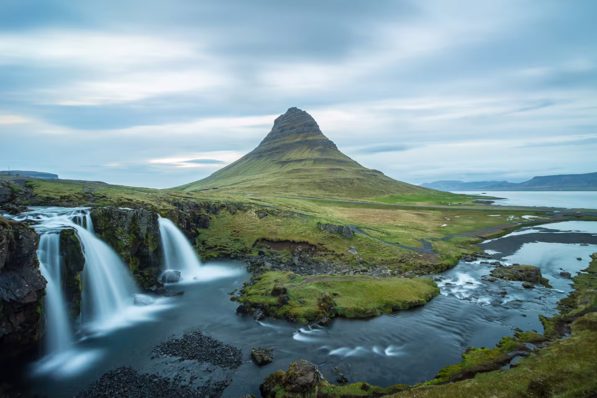 A picture of Kirkjufell with a waterfall to the left.