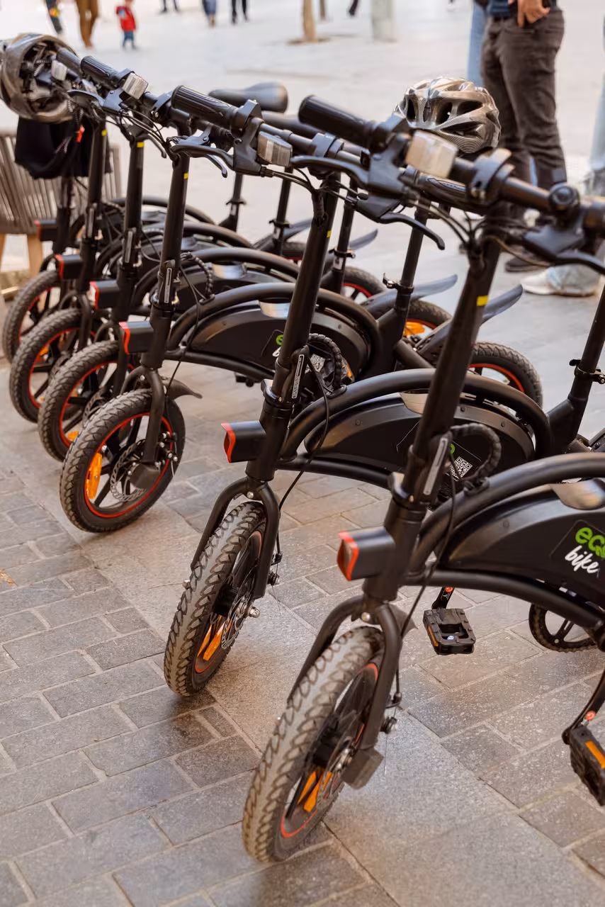 Row of eco e-bikes ready for the Knossos Palace Heraklion guided tour, helmets on handlebars in Crete