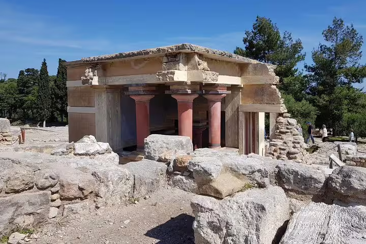 Discover the iconic red columns of Knossos Palace, a testament to Minoan civilization amidst scenic landscapes in Crete.