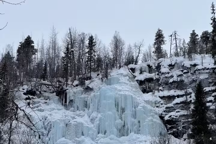 Marvel at the stunning Korouoma ice formations nestled within a tranquil snowy forest in Finland's winter wonderland.