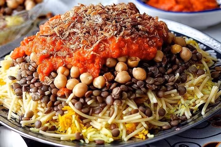 Koshari street food in Cairo with lentils, chickpeas and tomato sauce on Islamic Cairo walking tour