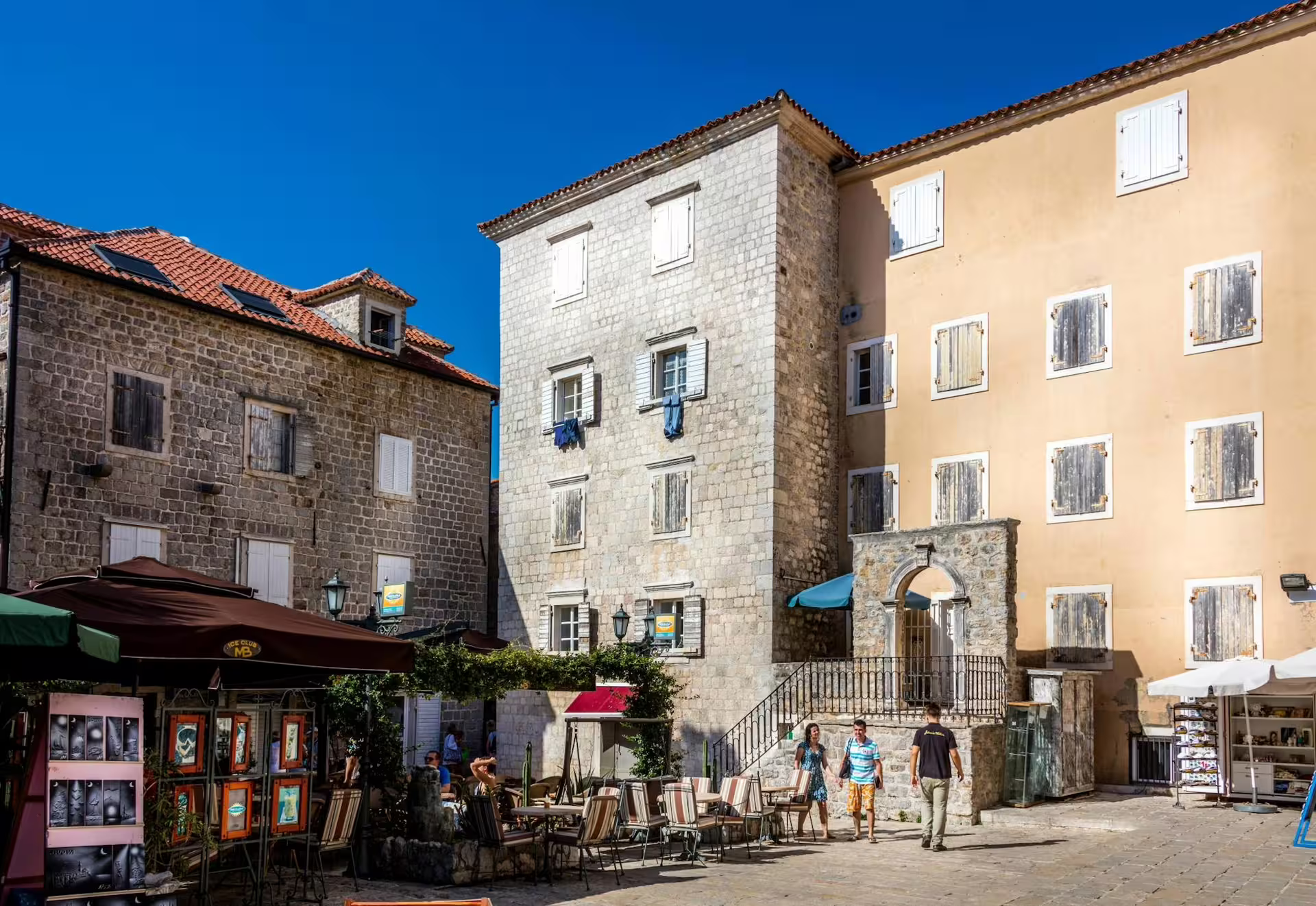 Kotor Old Town square with stone buildings and cafes, a scenic stop on Bay of Kotor cruise from Dubrovnik
