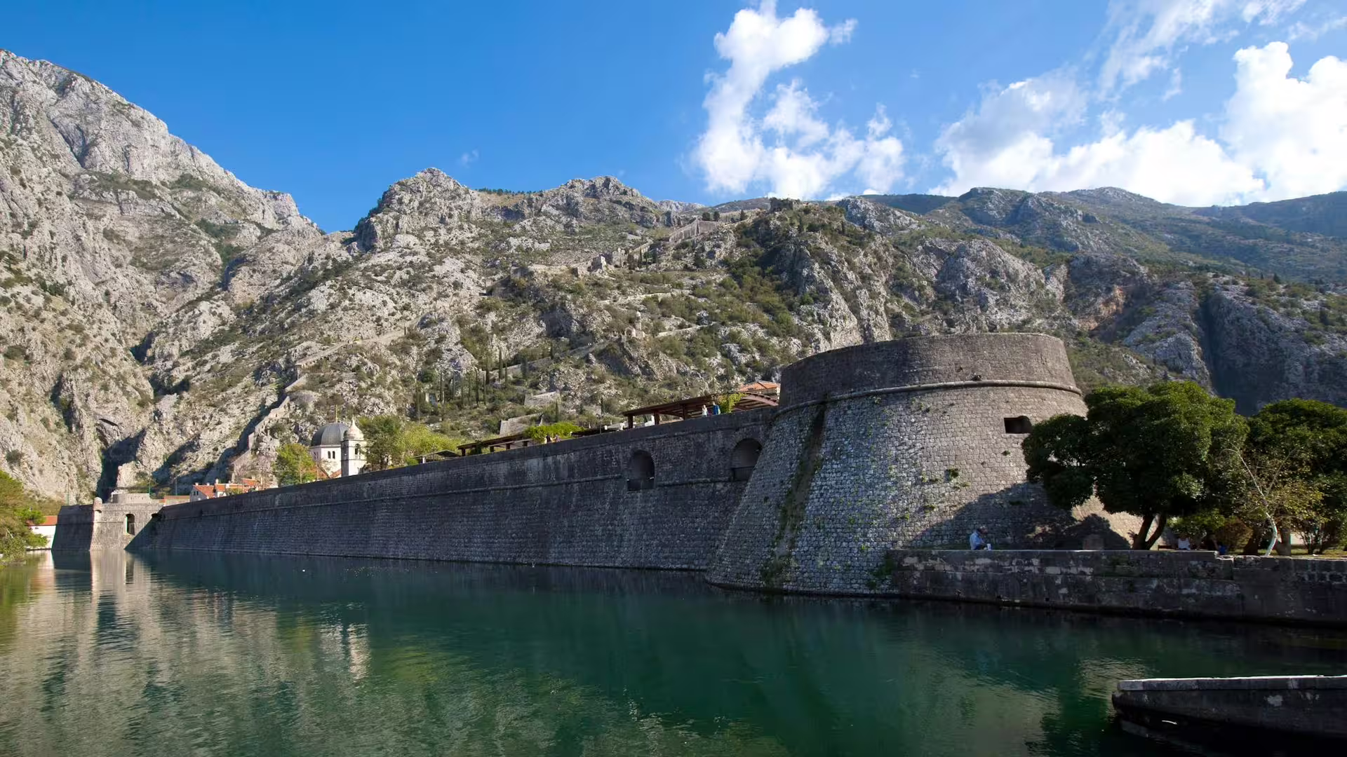 Kotor Old Town fortress walls by the water with mountains behind, a must-see stop on the Montenegro day trip from Dubrovnik