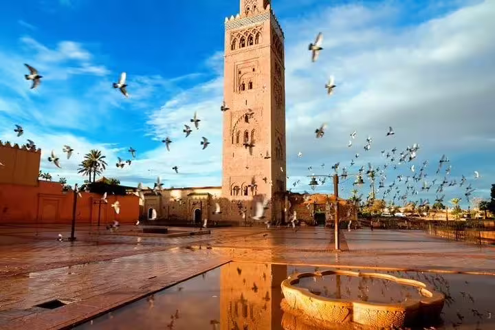 Koutoubia Mosque minaret in Marrakech with birds in flight, included on Morocco Amazing 12 Days Tour From Tanger