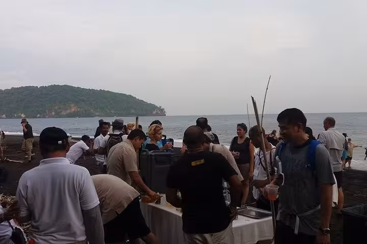 Krakatoa day tour beach picnic setup with guides and guests on volcanic black sand by the Sunda Strait
