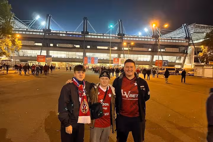 Local guide and fans outside Krakow football stadium at night, joining a matchday experience with locals