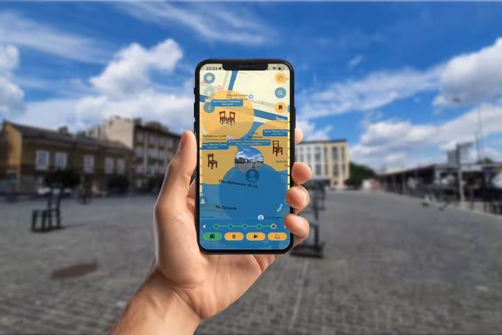 Hand holding smartphone displaying interactive map of Krakow Jewish Quarter walking tour with scavenger hunt icons