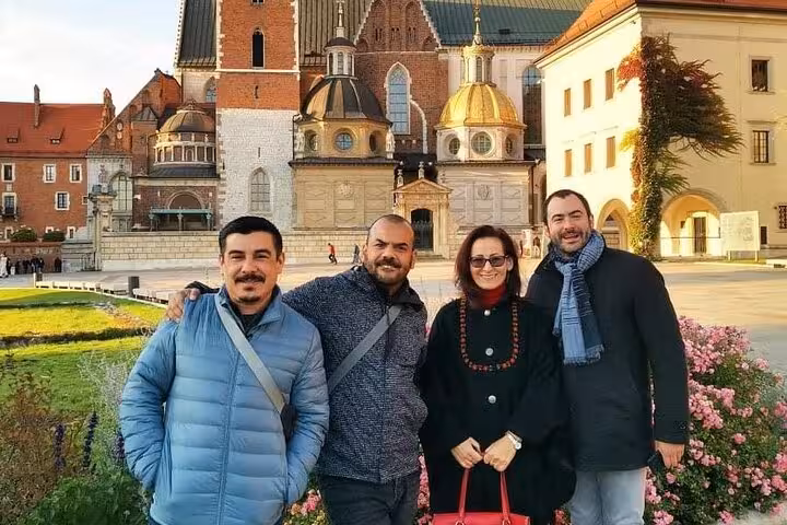 Group of tourists smiling in front of historic architecture in Krakow's Jewish Quarter on a walking tour.