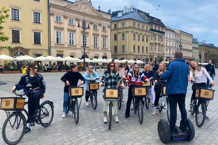 Tour participants listen to a guide on a Segway in Krakow's historic city center, ready for exploration.