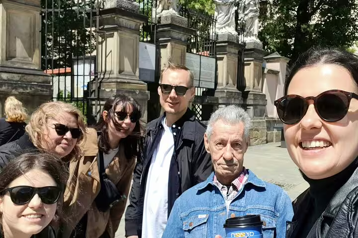 Group of tourists taking a selfie in front of historic gates in Krakow Old Town
