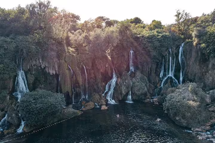 Kravice Waterfalls lagoon with multiple cascades and forest scenery, highlight of the Mostar tour