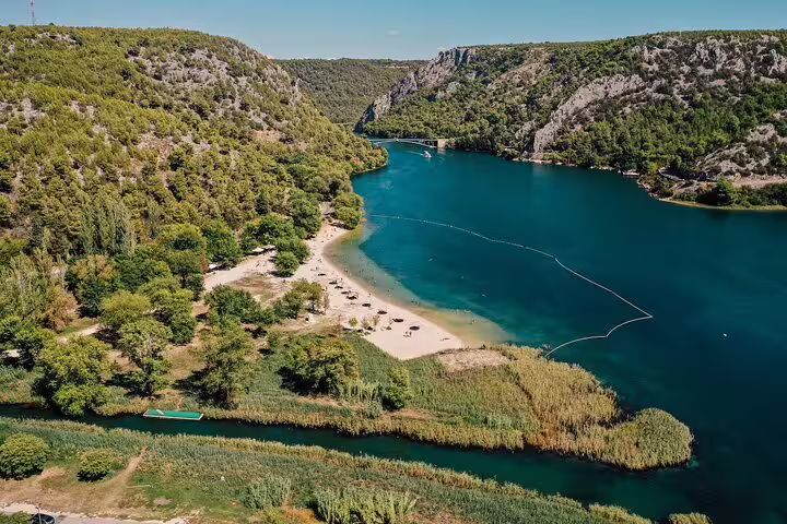 Aerial view of Krka River lagoon and forested cliffs on a private Krka Waterfalls tour from Split