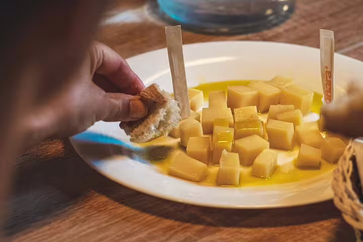 Dalmatian cheese cubes with olive oil and bread during food tasting stop on Krka Waterfalls wine tour