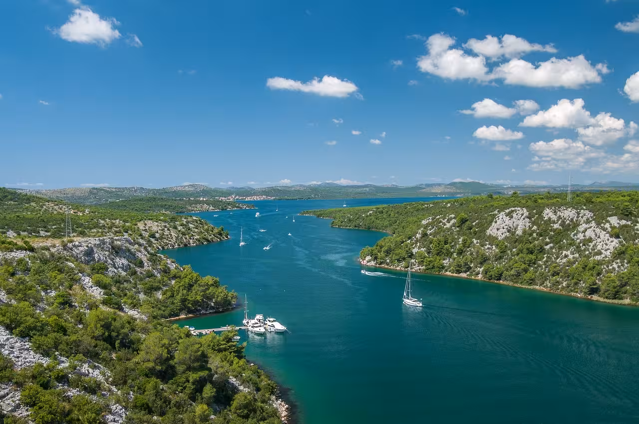 Scenic Krka River lake cruise route near Skradin, turquoise water and sailboats on Krka Waterfalls day trip