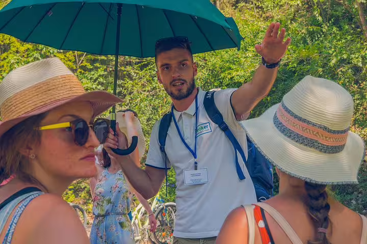 Tour guide briefing guests at Krka Waterfalls, part of scheduled day trip with food and wine tasting