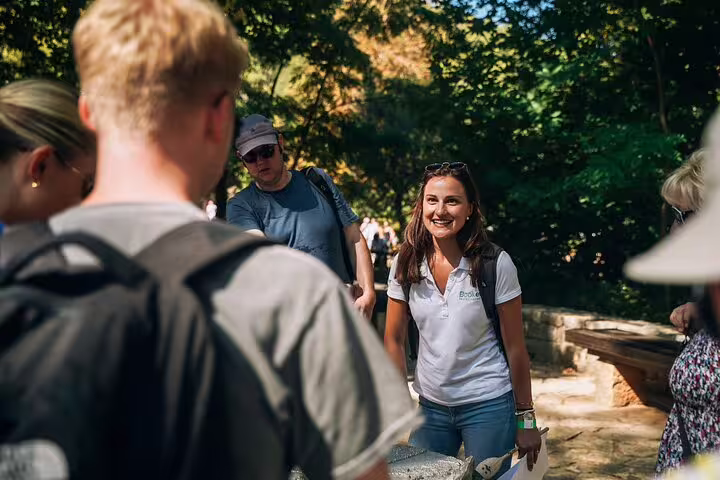 Tour guide greeting guests on shaded trail in Krka National Park during scheduled Krka Waterfalls day trip