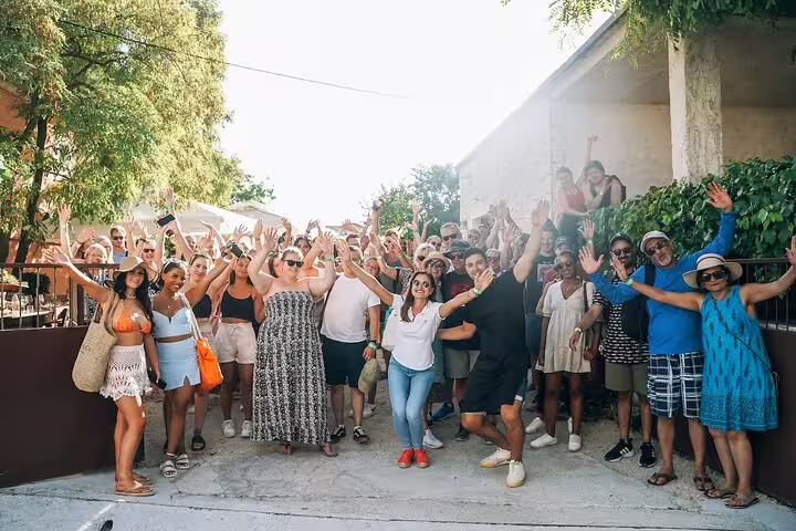 Happy group photo at a winery stop on a private Krka Waterfalls tour, optional wine tasting near Skradin