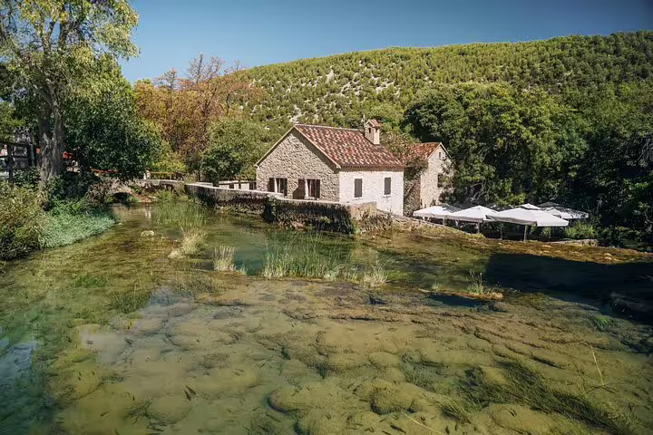 Traditional stone watermill by clear river at Krka National Park on scheduled Krka Waterfalls tour with swimming