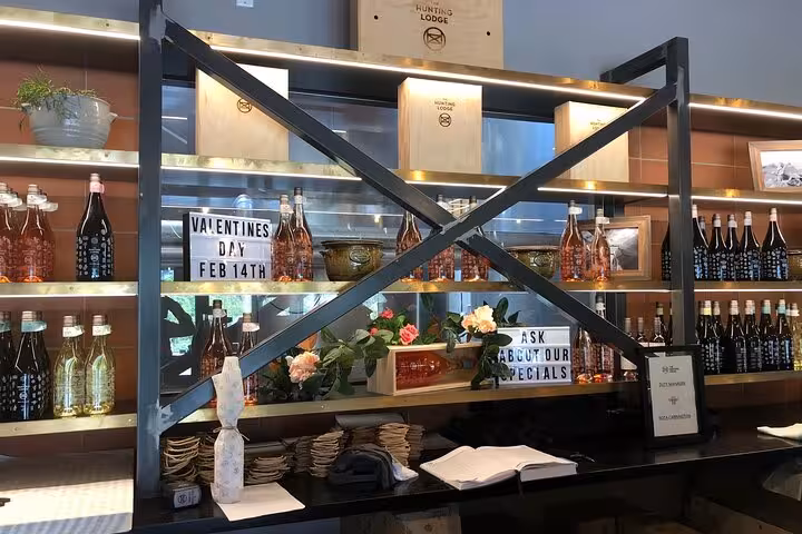 Elegant wine display at Kumeu tasting room featuring a variety of bottles and decor celebrating Valentine's Day specials.
