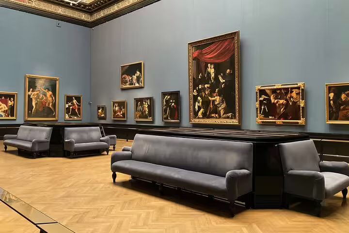 Art gallery room at Kunsthistorisches Museum Vienna with classic paintings and seating for visitors.