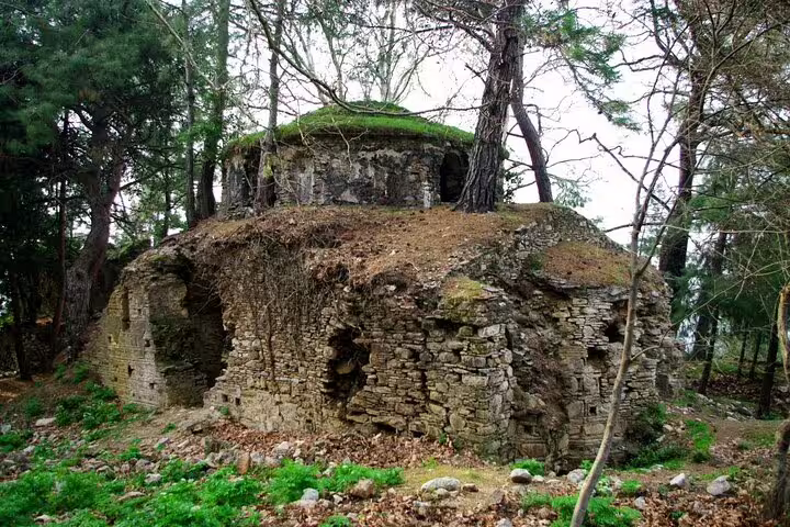 Ancient stone ruins surrounded by lush forest, a historical stop on the Kusadasi jeep safari to the national park.