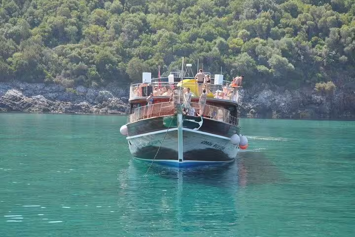 Front view of a boat cruising through serene waters surrounded by lush greenery on a Kusadasi/Selcuk tour.