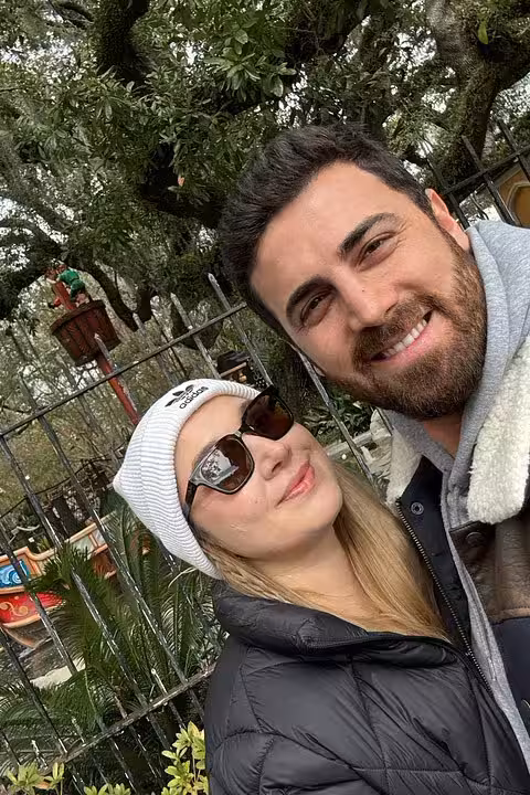 Couple smiling for selfie outdoors at New Orleans City Park surrounded by trees