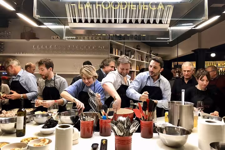 Participants enjoy a hands-on cooking class at La Boqueria Market tour in a stylish Barcelona loft kitchen.