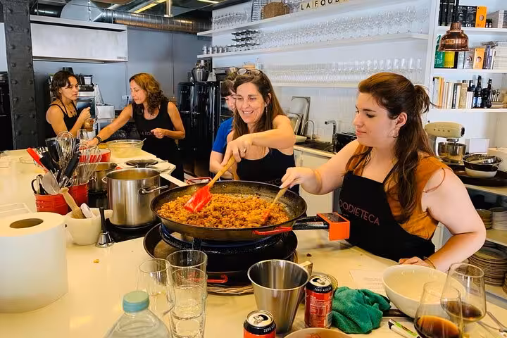 Participants enjoy cooking a vibrant dish during the La Boqueria Market Tour & Premium Cooking Class in a designer loft.