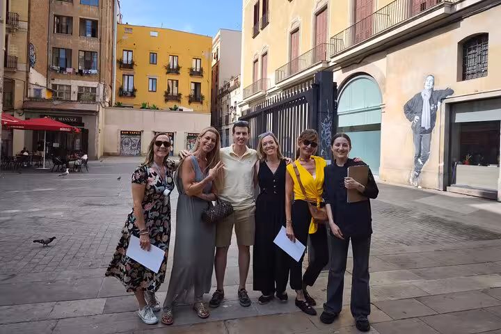 Tour group poses in a charming Barcelona plaza, part of the La Boqueria Market Tour & Premium Cooking Class experience.