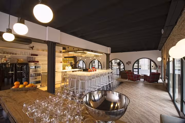 Elegant designer loft set up for a premium cooking class, featuring modern kitchen and stylish dining area in Barcelona.