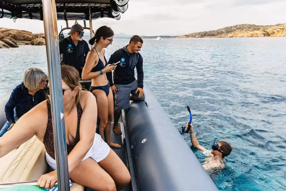 Tourists enjoy snorkeling from a RIB boat in the clear waters of La Maddalena Archipelago, perfect for adventure seekers.