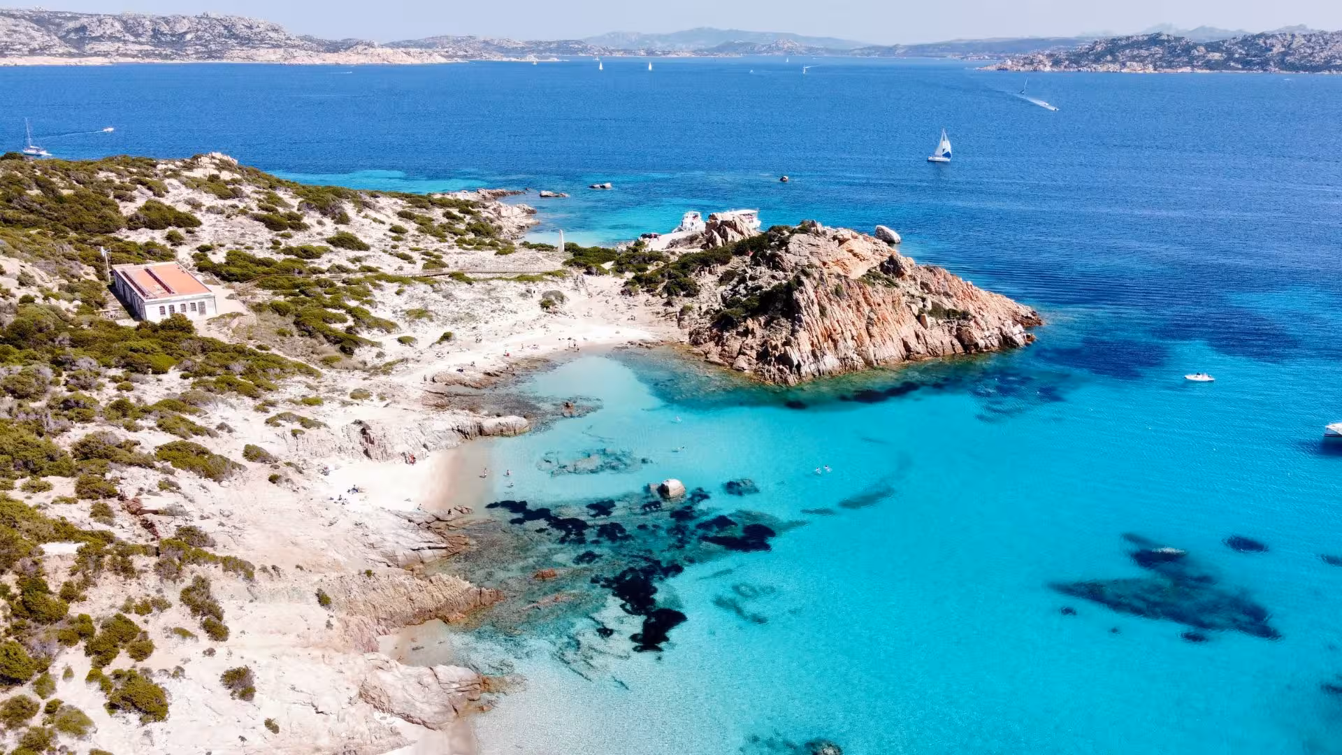 Aerial view of La Maddalena's pristine beaches and azure waters, perfect for a mini yacht excursion adventure.