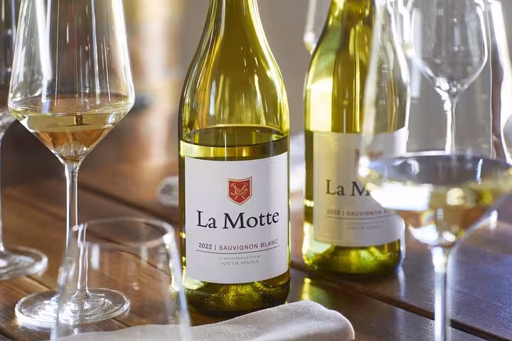 Close-up of La Motte Sauvignon Blanc bottles and glasses, highlighting Cape Town's premier wine tasting tour.