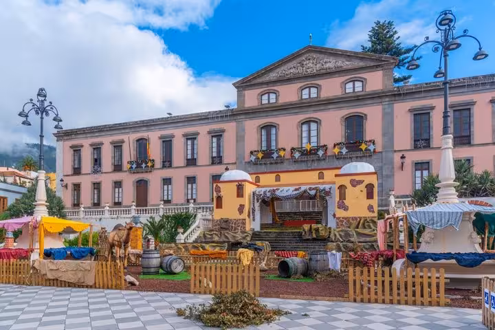 Pink neoclassical town hall building in La Orotava with a colorful Christmas nativity scene in the plaza