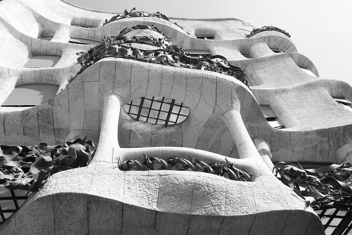 Unique architectural design of La Pedrera with twisting stone balconies and wrought-iron details.