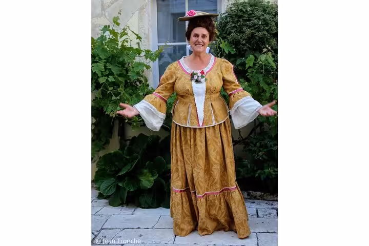 Guide in golden 18th century period costume with hat at La Rochelle walking tour