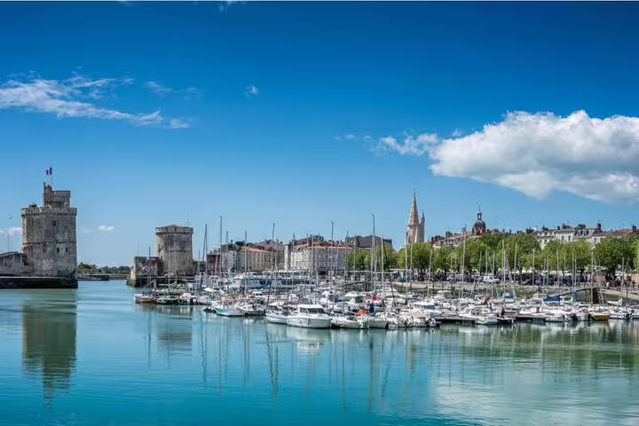 La Rochelle old port marina with medieval towers and sailboats reflecting on calm blue water