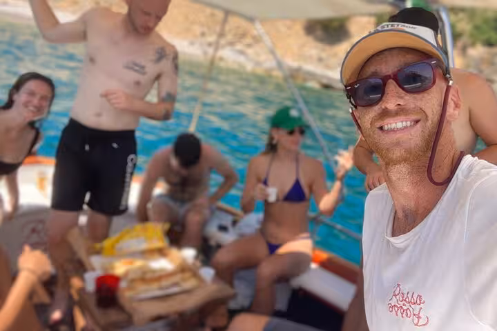 Group of friends enjoying snacks and drinks on a boat during the La Spezia 3h tour, under sunny skies.