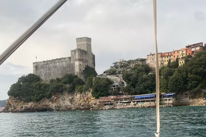 View of the historic castle and colorful hillside homes from a boat on the La Spezia tour to Portovenere.