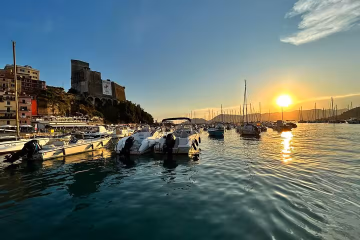 Golden sunset over a marina with boats in La Spezia, ideal for a scenic boat tour in Golfo Dei Poeti.
