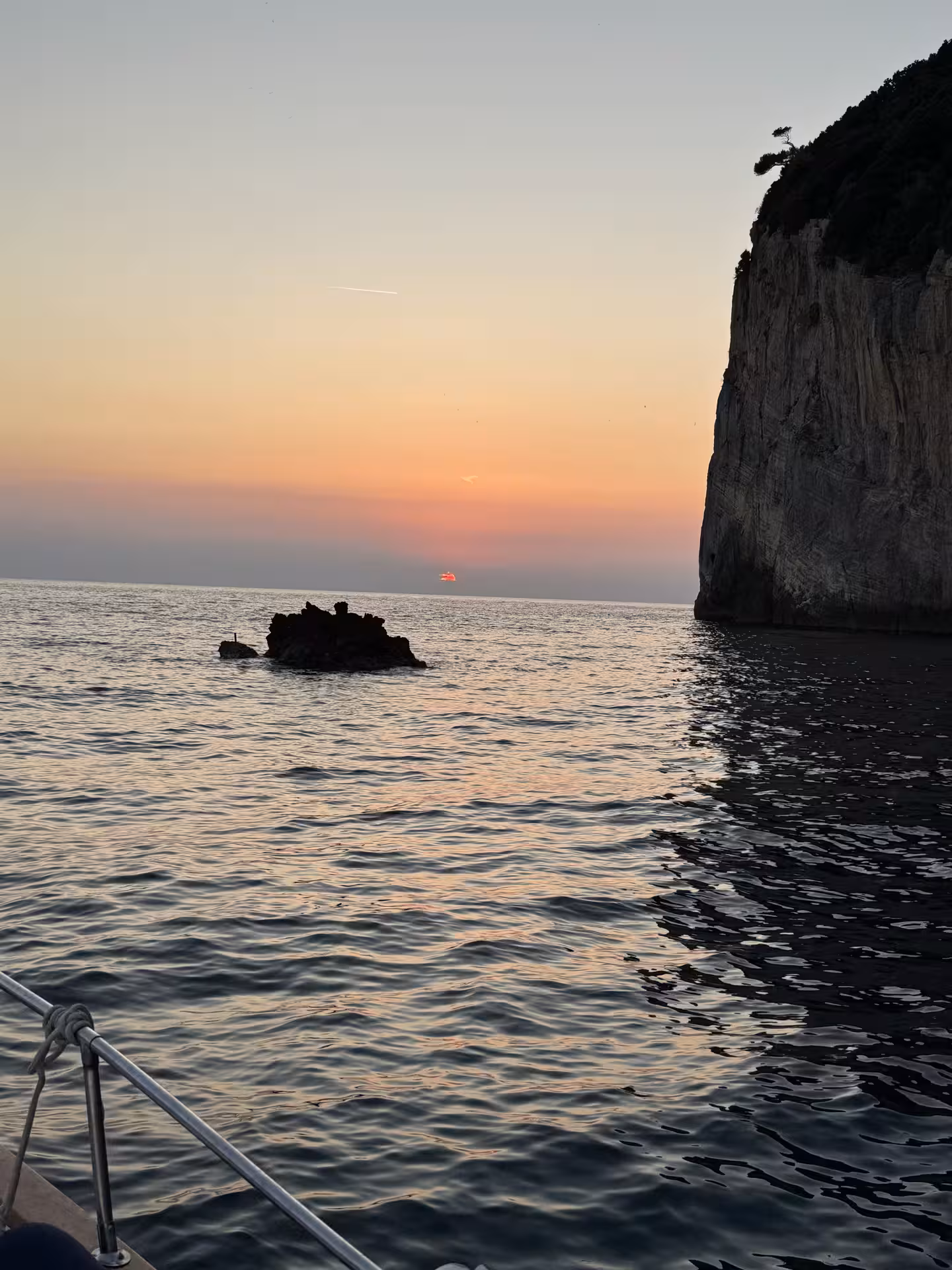 Serene sunset view from a boat tour in Golfo Dei Poeti, highlighting La Spezia's stunning coastline.