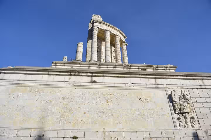 Ancient Roman trophy monument with Latin inscriptions and Corinthian columns against blue sky, La Turbie French Riviera