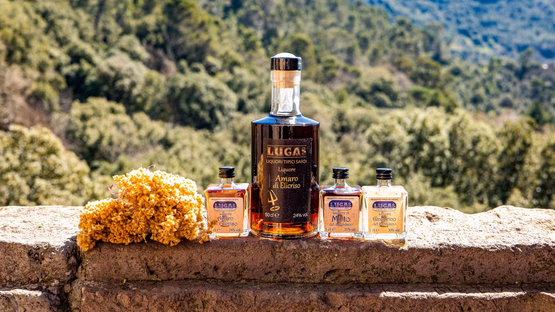 Assorted Lugas liqueurs with Amaro di Elicriso and wildflowers, set against a scenic Sardinian landscape.