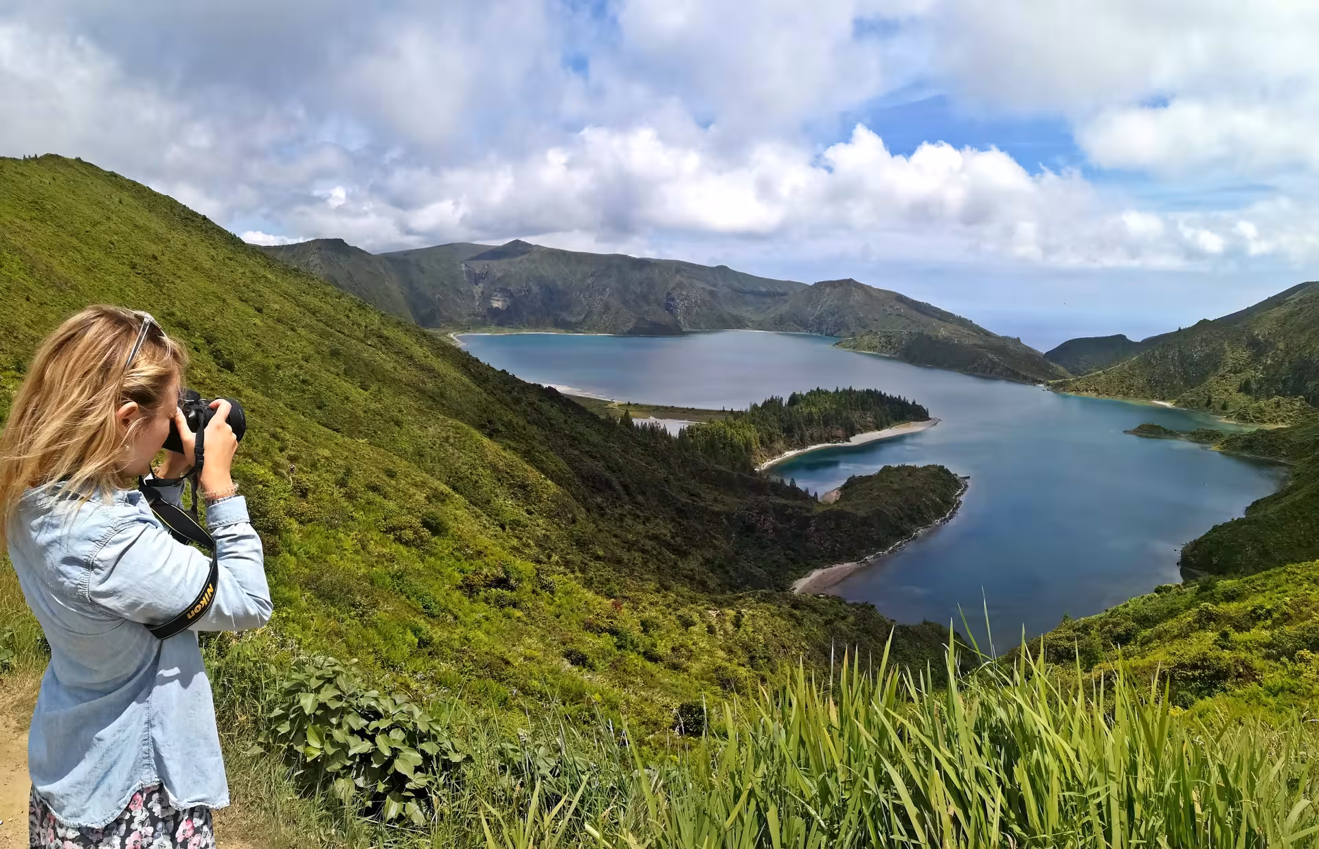 Traveler photographing Lagoa do Fogo viewpoint on São Miguel, Azores during a half-day van sightseeing tour