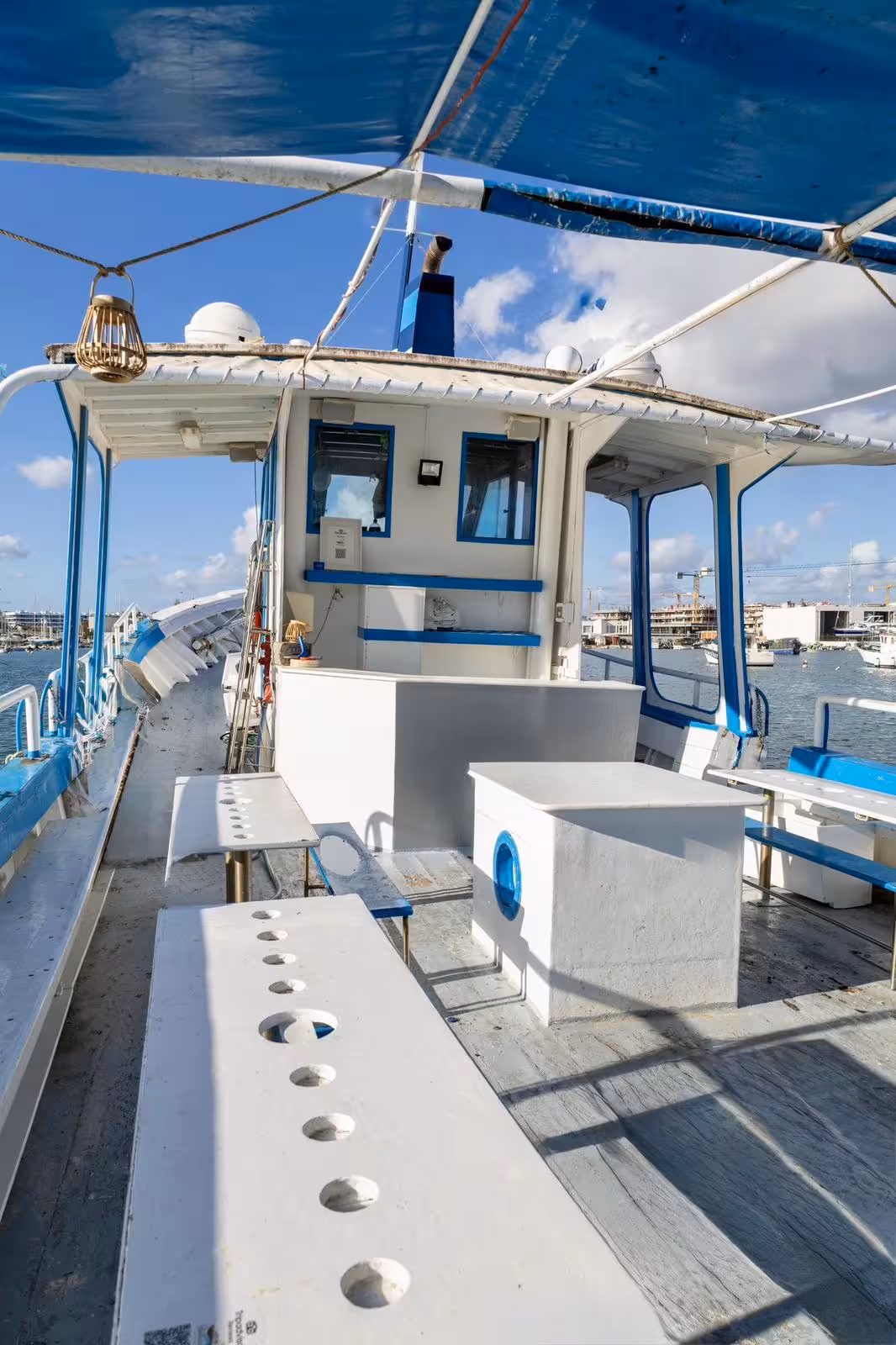 Open deck of a blue and white tour boat docked in Lagos marina for an Algarve coastline cave tour