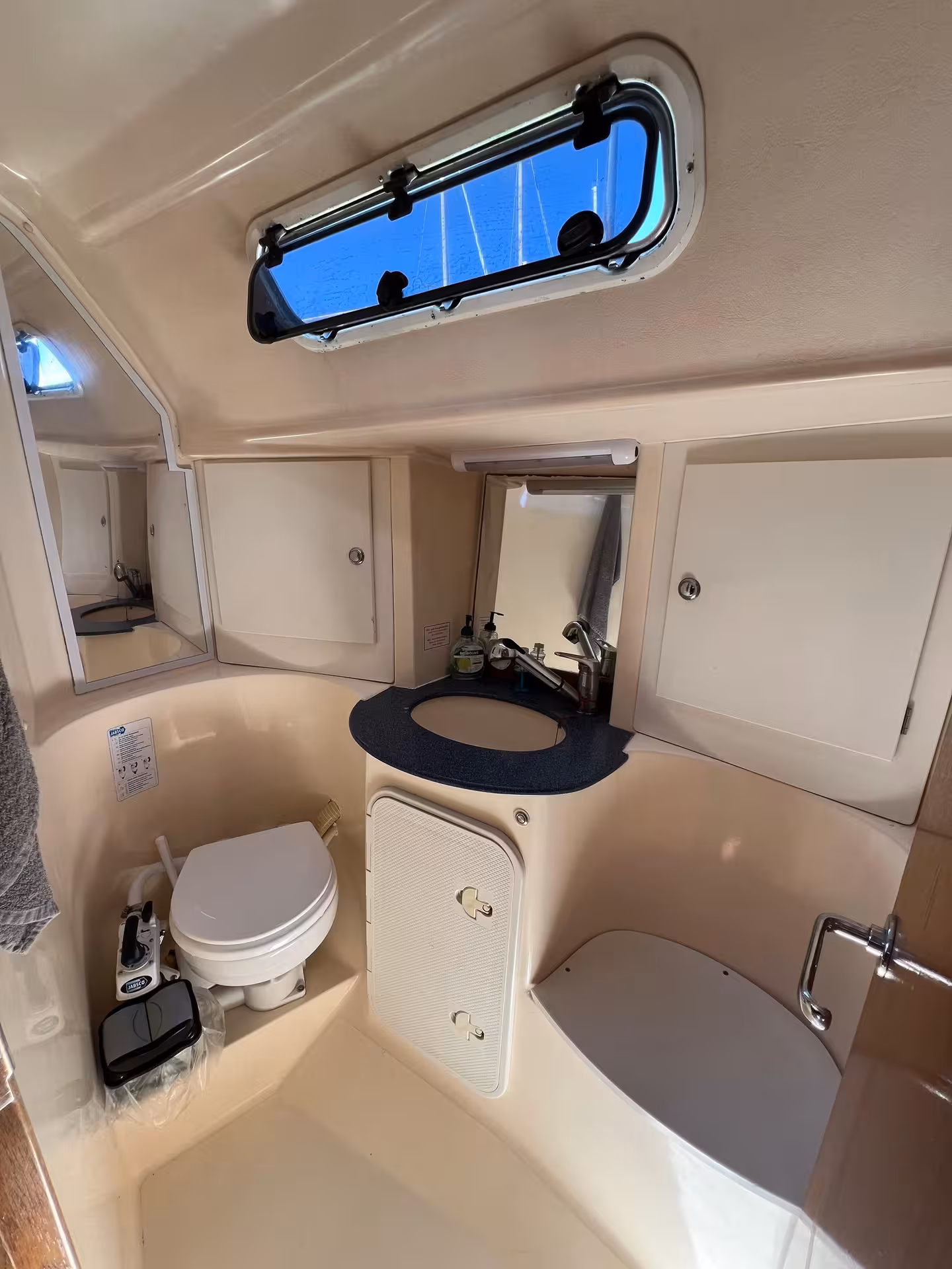 Clean yacht bathroom with toilet, sink and skylight onboard Lagos full-day yacht cruise in Algarve