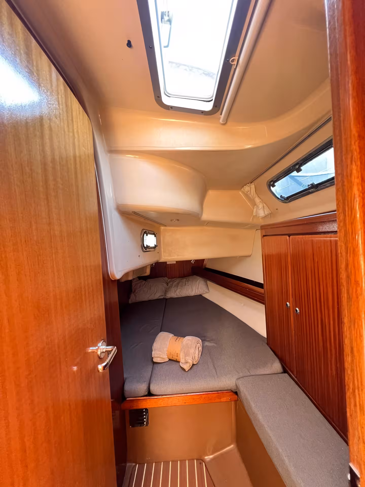 Private yacht guest cabin with double bed and hatch windows on a full-day Lagos yacht cruise experience